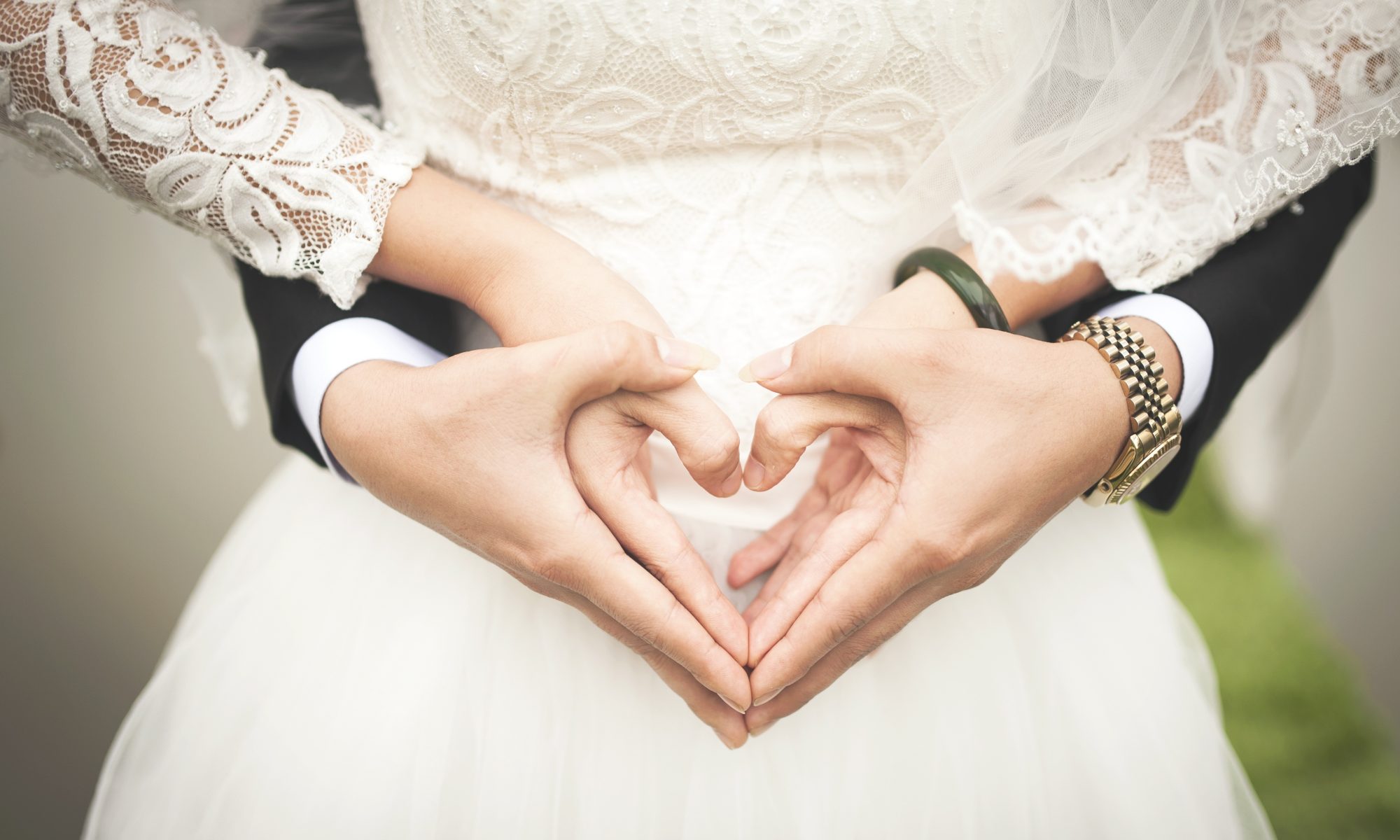 Husband and wife create heart shape with hands to celebrate marriage. Marriage Ceremony